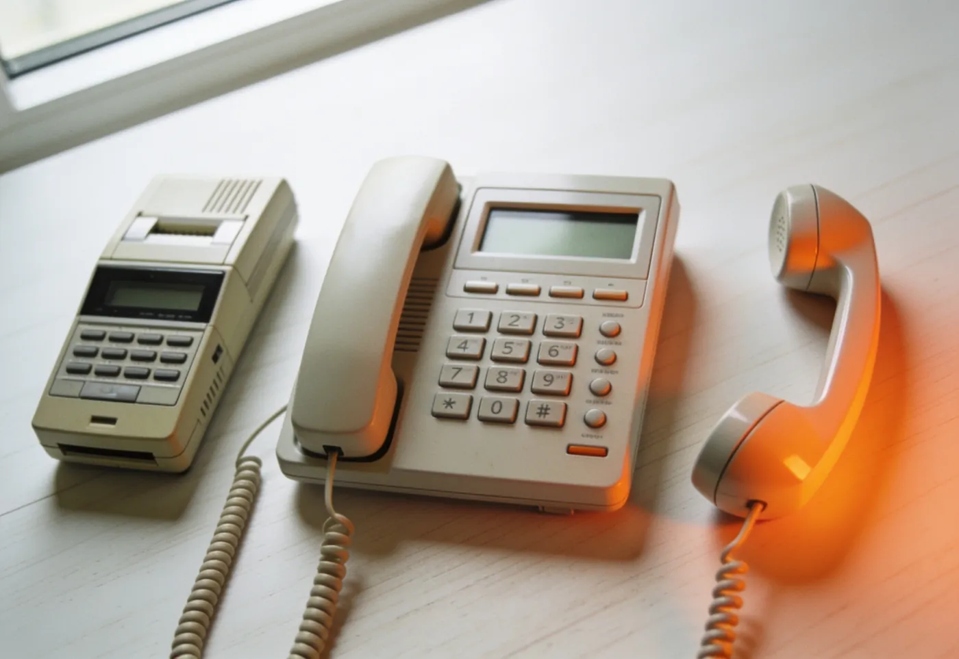 Trois téléphones alignés représentant les trois niveaux d'accueil automatique : répondeur, poste à touches et combiné moderne